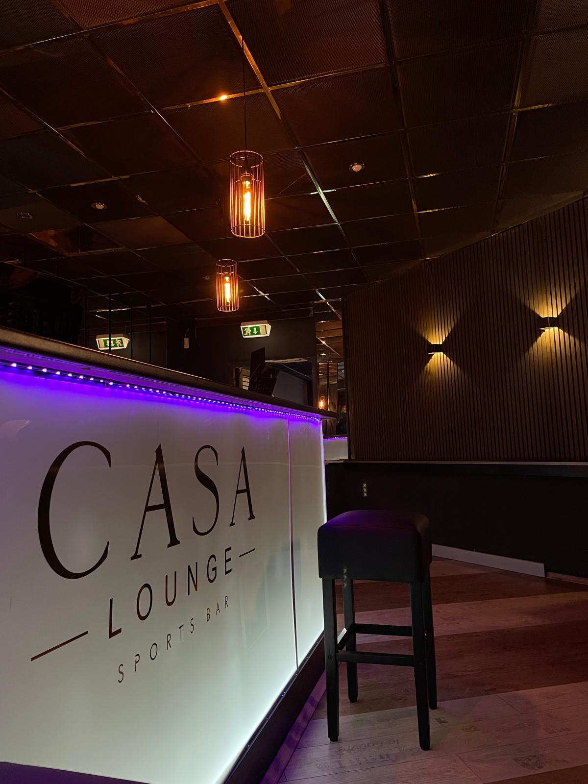 Beleuchtete Bar-Front mit Casa-Lounge-Schriftzug